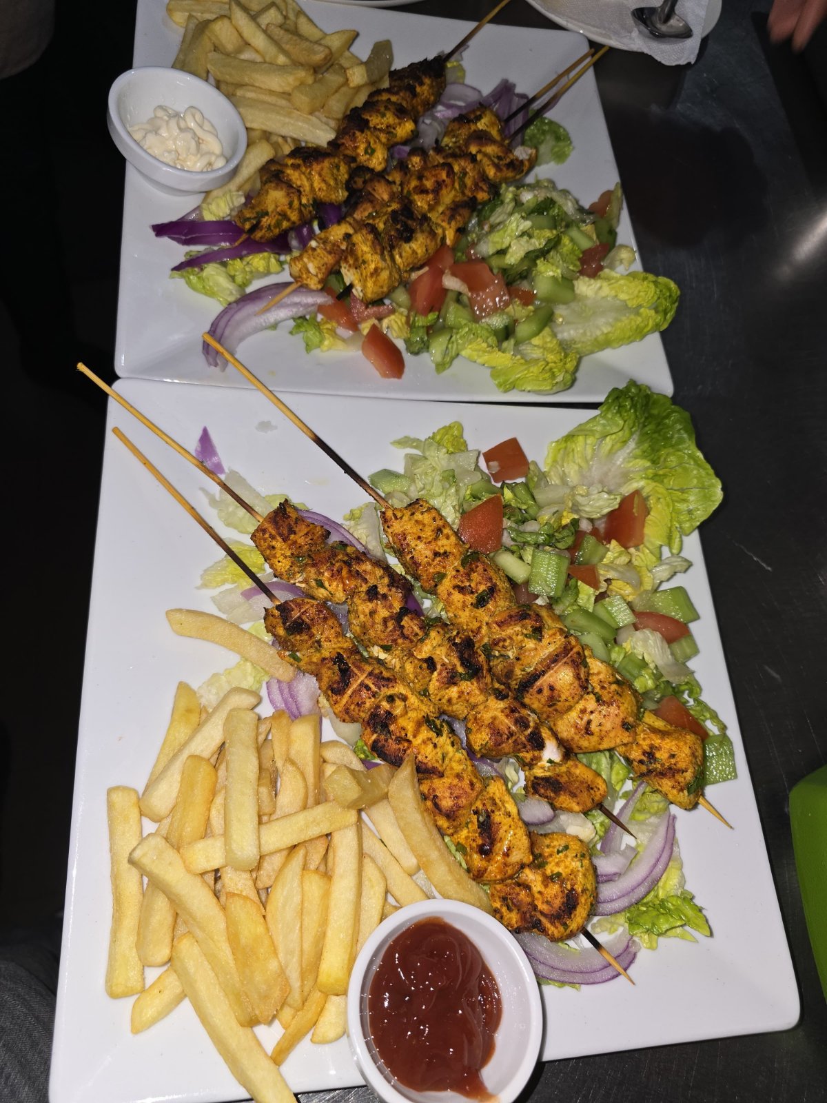 Grilled chicken skewers with fries and fresh salad