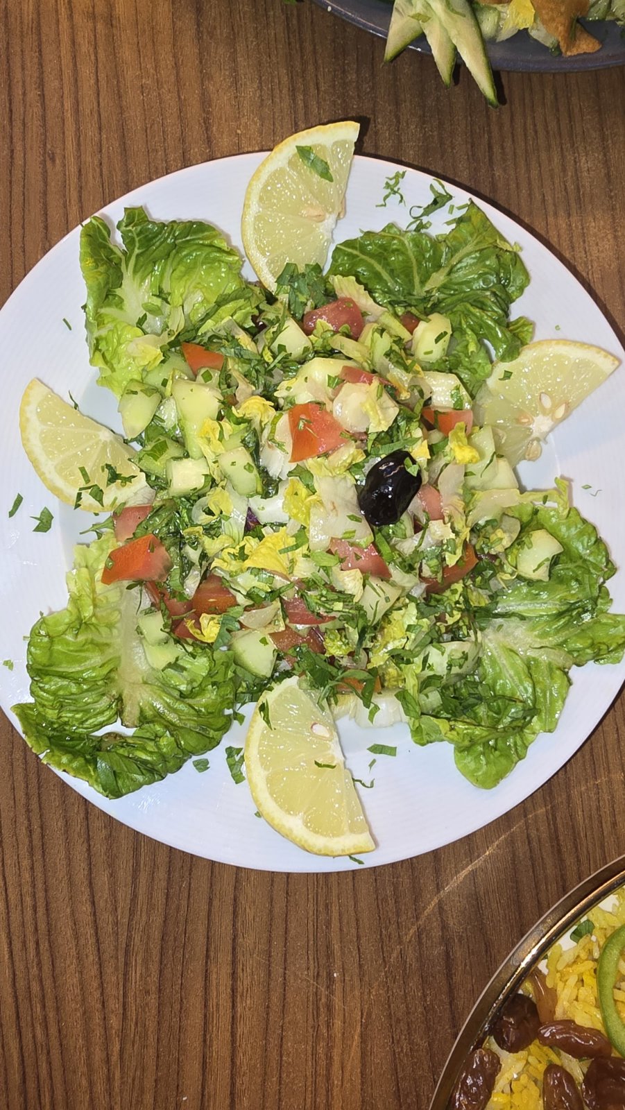 Fresh chopped salad with lemon wedges and black olive