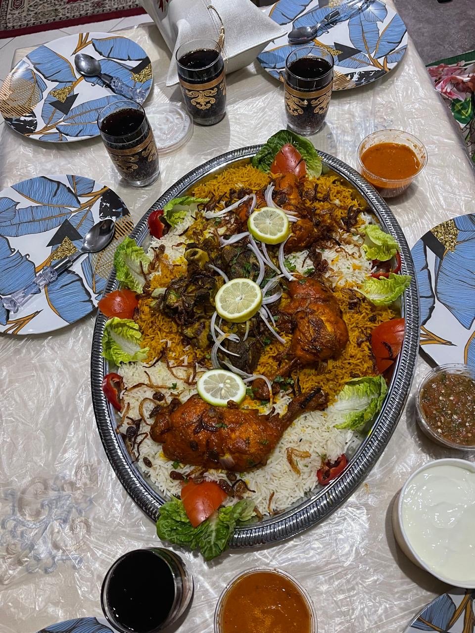 Chicken platter with white and saffron rice, served with dips at a festive table setting