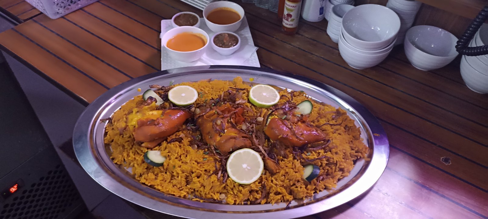 Chicken quarters over saffron rice with lime and cucumber, served with side sauces