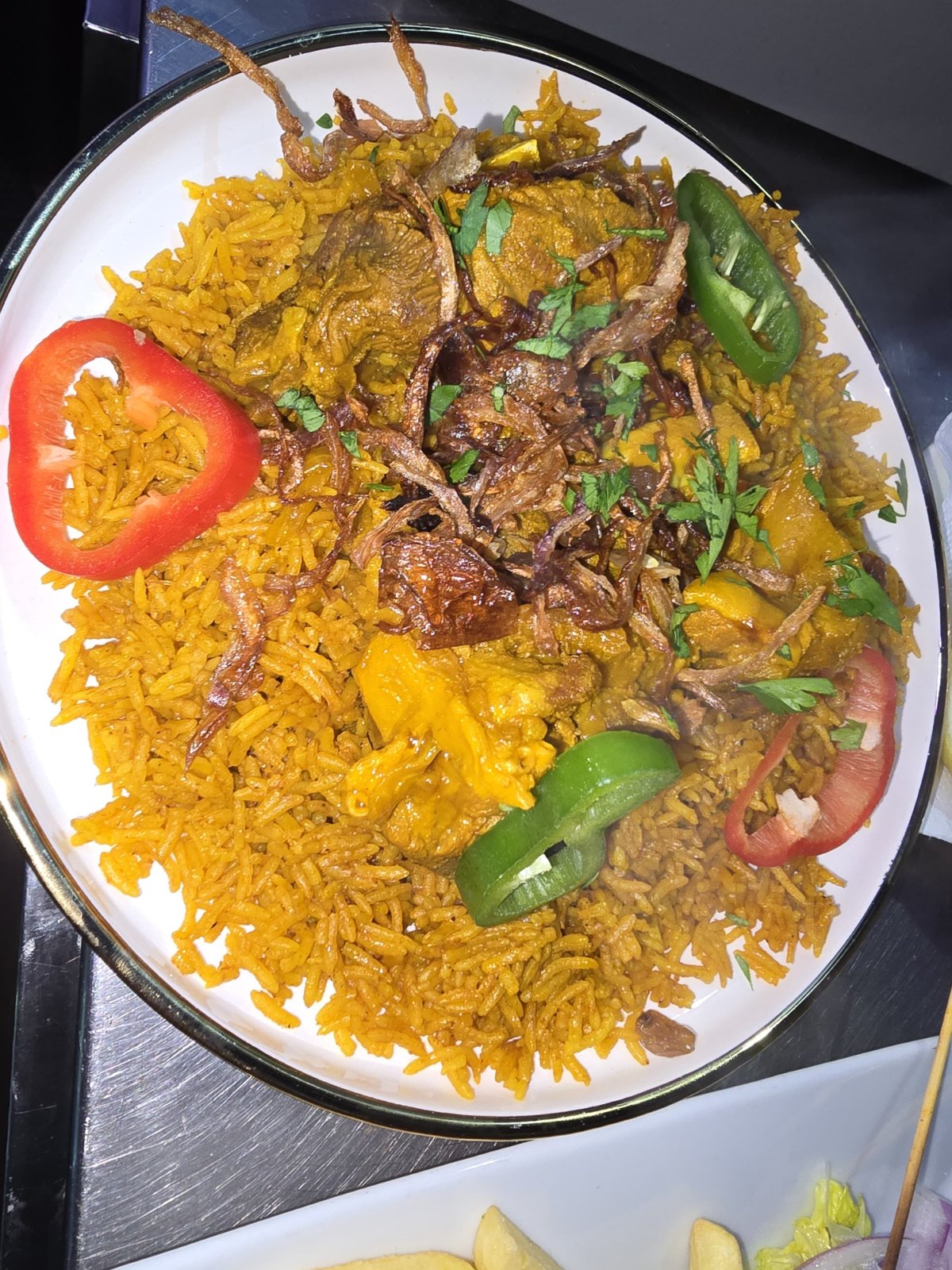 Shredded lamb kabsa over saffron rice with fried onions and chili