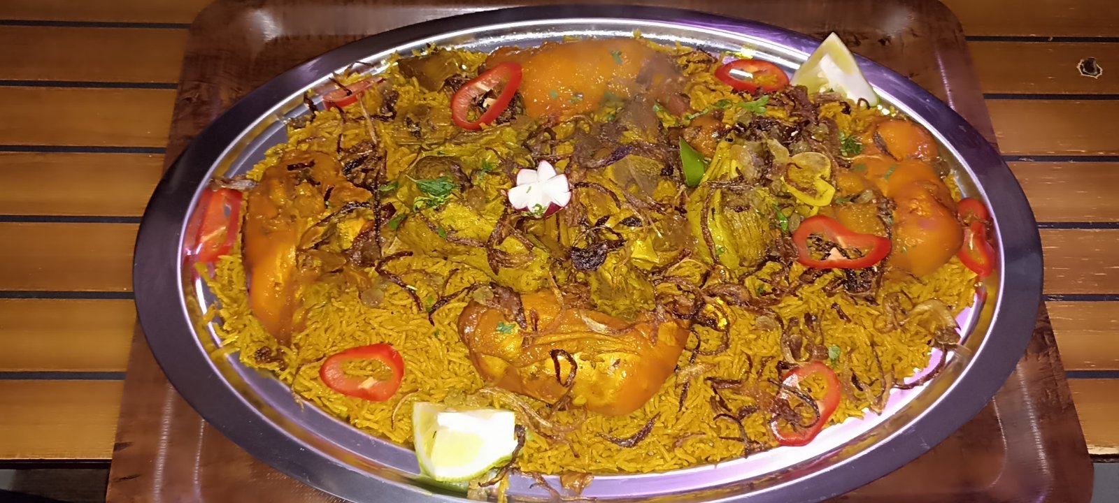 Chicken mandi platter over saffron rice with pepper and radish garnish