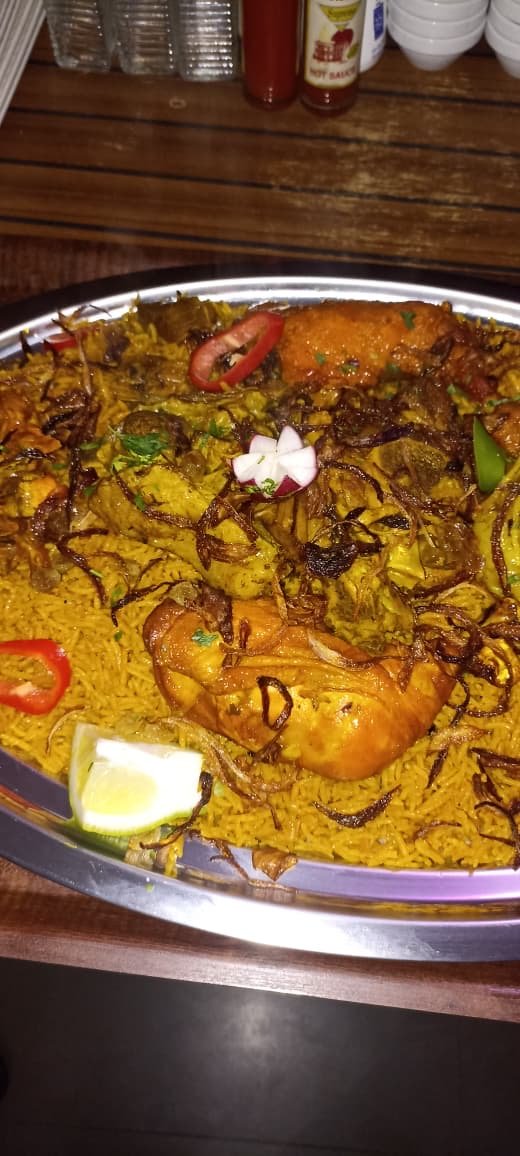 Chicken kabsa over saffron rice with radish flower garnish